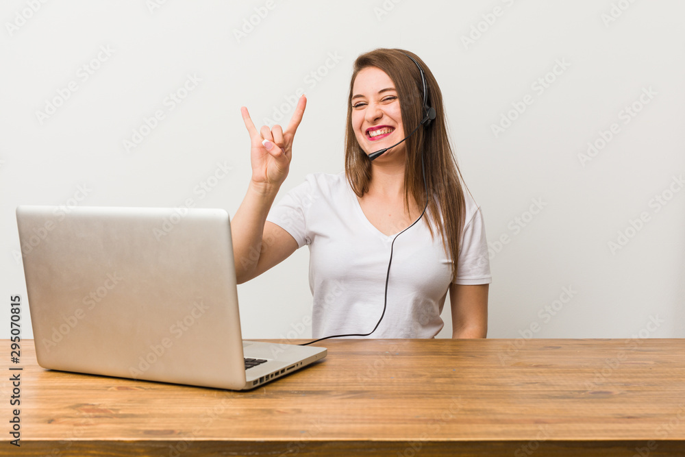 Young telemarketer woman showing a horns gesture as a revolution concept. Young telemarketer woman showing a horns gesture as a revolution concept.
