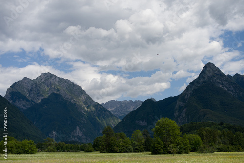 Mountain landscape with valley and trees and little parachutist