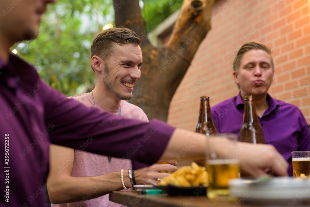 Happy man talking and drinking beer with friends Happy man talking and drinking beer with friends