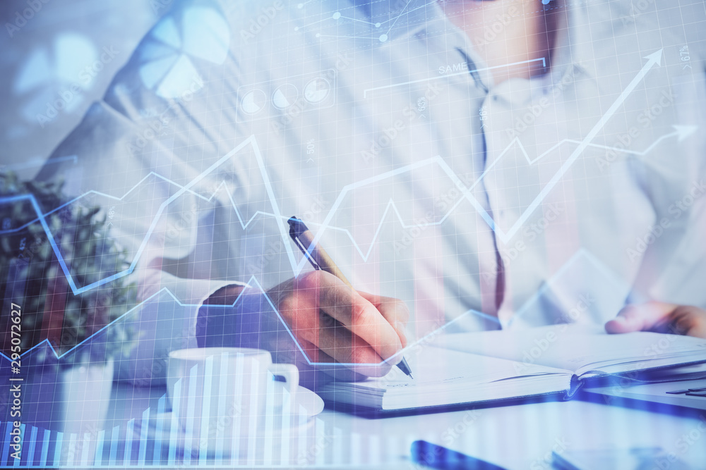 Double exposure of man's hands writing notes of stock market with forex chart. Double exposure of man's hands writing notes of stock market with forex chart.