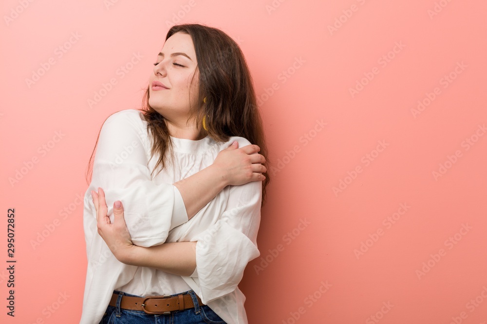 Obraz premium Young caucasian curvy woman standing against pink background