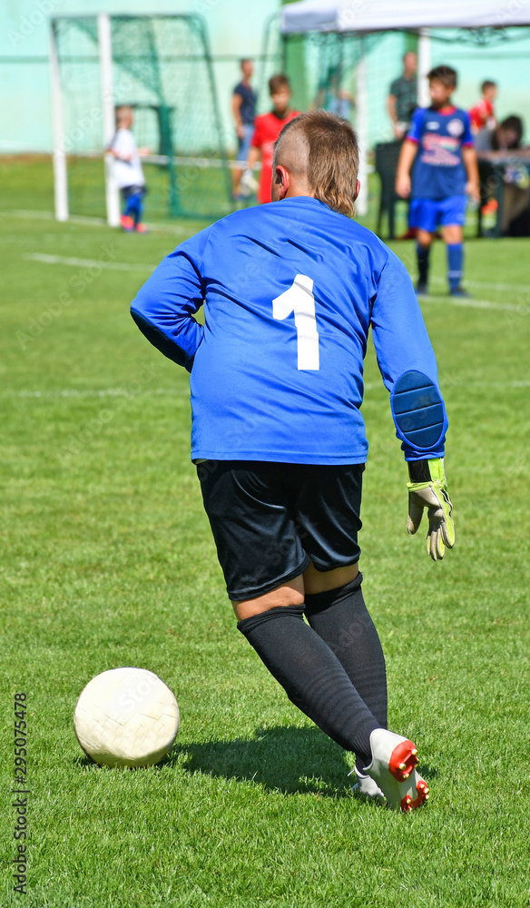 Young goalkeeper kicks the ball out Young goalkeeper kicks the ball out