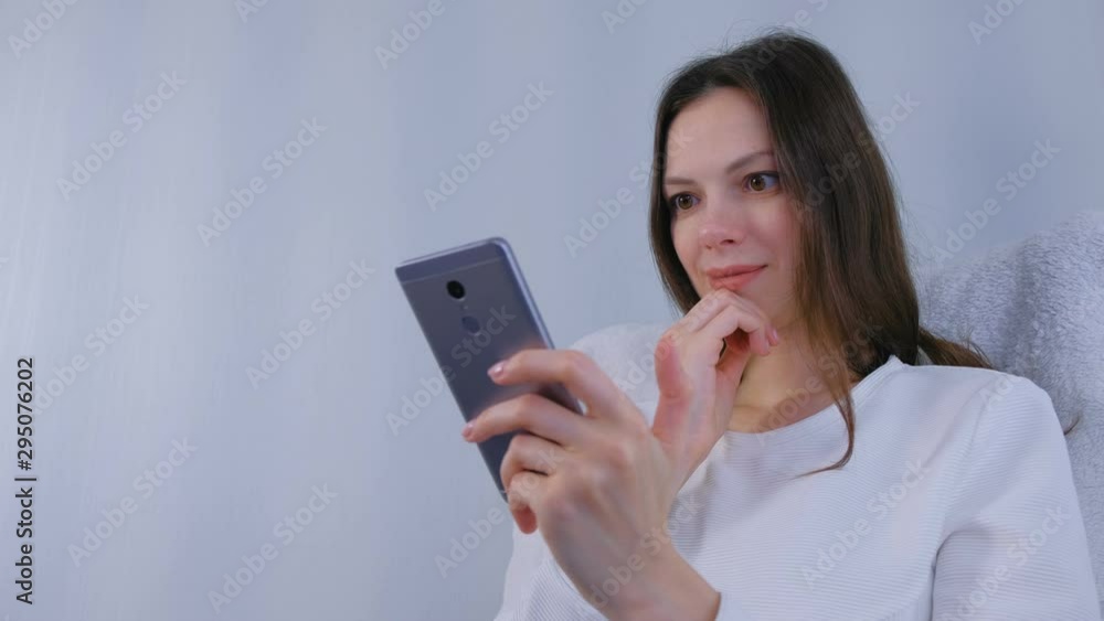 Woman watches funny video on mobile phone Woman watches funny video on mobile phone