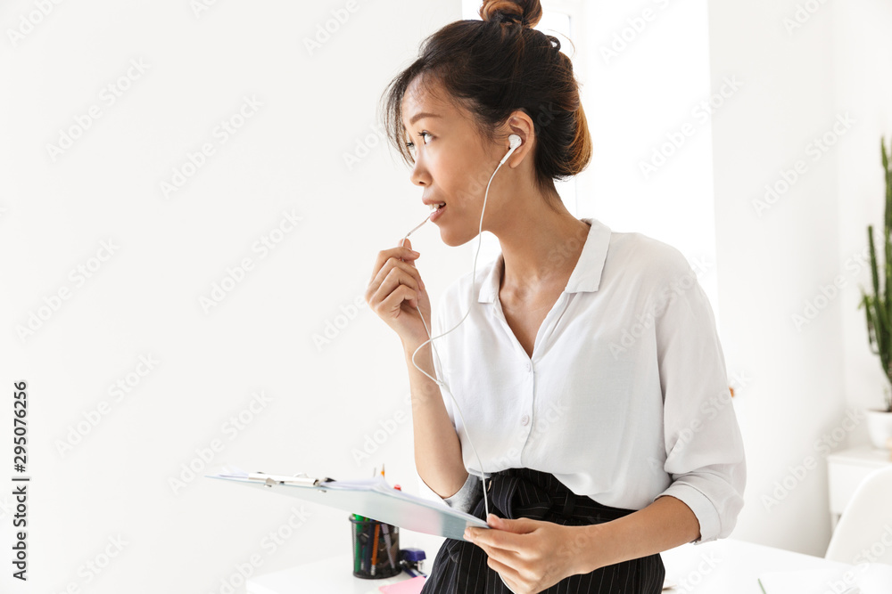 Confident attractive young asian businesswoman standing at her office Confident attractive young asian businesswoman standing at her office