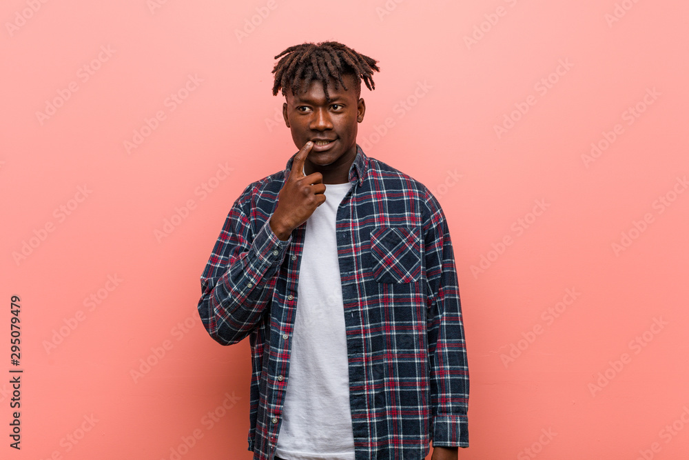 Young african black man looking sideways with doubtful and skeptical expression. Young african black man looking sideways with doubtful and skeptical expression.
