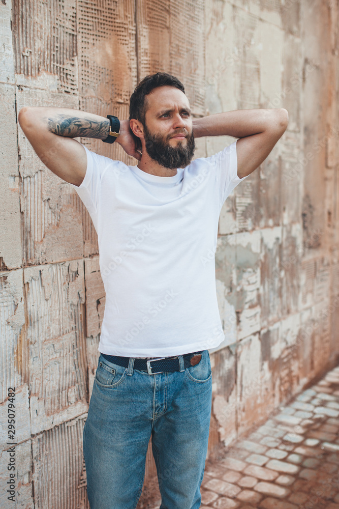Handsome hipster man with beard wearing white blank t-shirt with space for your logo or design. white t shirt mockup. Handsome hipster man with beard wearing white blank t-shirt with space for your logo or design. white t shirt mockup.