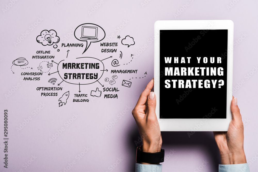 cropped view of woman holding digital tablet with what your marketing strategy lettering on purple cropped view of woman holding digital tablet with what your marketing strategy lettering on purple