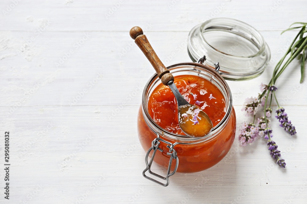 Apricot lavender marmalade in a glass jar on a rustic wooden table