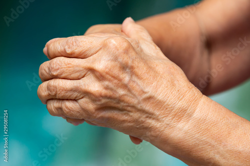 Senior woman's touching her hands and praying, Close up & Macro shot, Selective focus, Asian Body skin part, Body language feeling, Religious concept