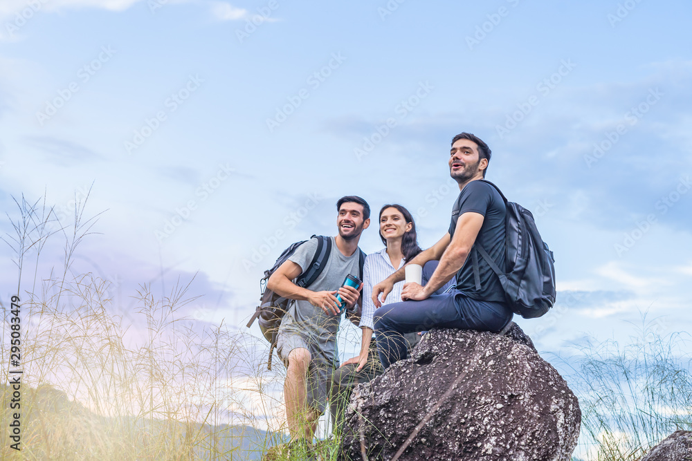Young tourists spend their holidays in the nature and forest tourism and looking at something exciting, and the beauty of refreshing from nature while sitting resting on the rocks.