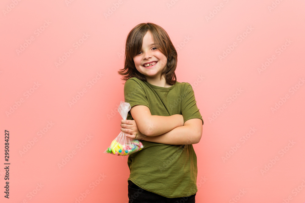 Little boy caucasian holding candies smiling confident with crossed arms. Little boy caucasian holding candies smiling confident with crossed arms.