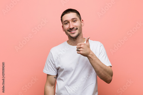 Young casual man smiling and raising thumb up