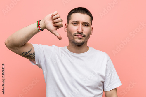 Young casual man showing a dislike gesture, thumbs down. Disagreement concept.
