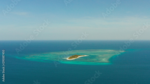 Small tropical island in the blue sea with a coral reef and the beach, top view. Summer and travel vacation concept. Canimeran Island, Balabac, Palawan, Philippines.