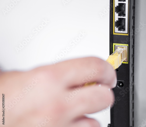 Hand plugging ethernet cable into router