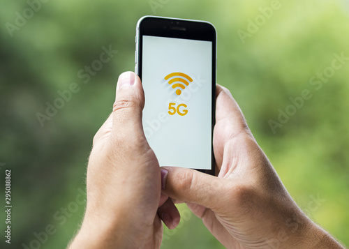 Phone with 5g on screen held in hands