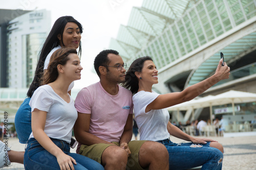 Joyful young people posing for self portrait. Smiling young people taking selfie with smartphone. Concept of self portrait