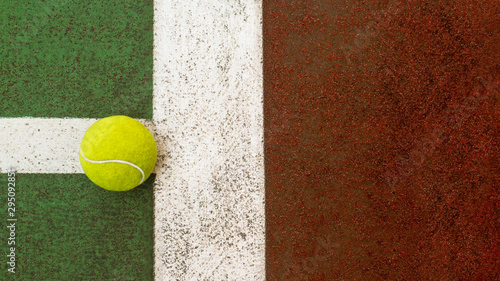 Yellow tennis ball hitting the sidelines on an green and orange artificial tennis court, sport background © leaw197340