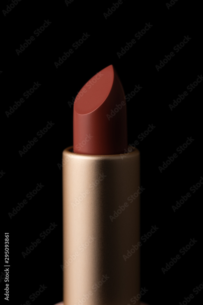 Red lipstick macro close-up isolated on black background.