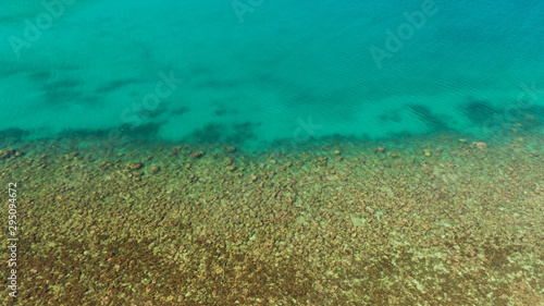 Fototapeta Naklejka Na Ścianę i Meble -  Aerial view clean sea surface copy space for text. Sea water surface in lagoon. Top view transparent turquoise ocean water surface. sea bottom with stones