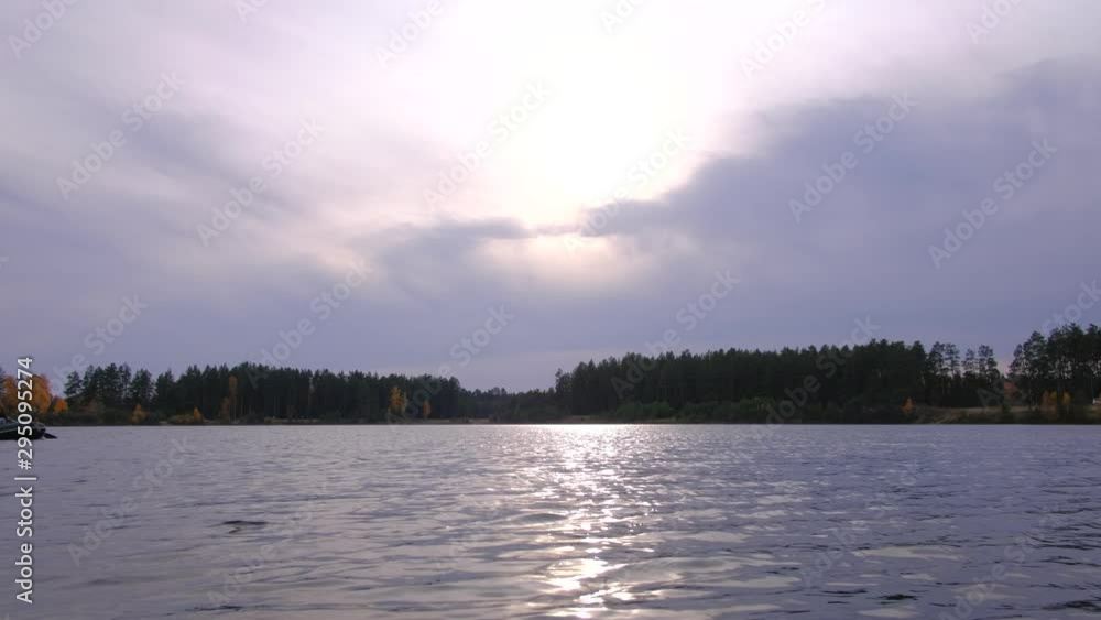 A woman floated on a rubber boat, rows and swims on a large lake in beautiful autumn forest. A woman floated on a rubber boat, rows and swims on a large lake in beautiful autumn forest.