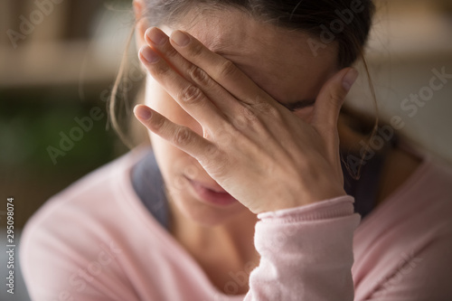 Sad tired woman touching face having headache or depression photo