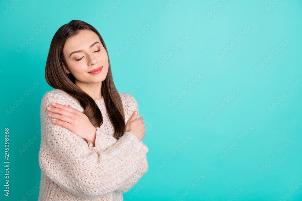 Turnde photo of pretty positive girl hug herself enjoy woolen cotton jumper isolated over teal turquoise color background Turnde photo of pretty positive girl hug herself enjoy woolen cotton jumper isolated over teal turquoise color background