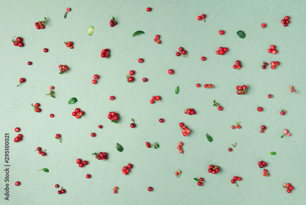Wild lingonberry pattern on green background. Top view. Summer berries texture. Wild lingonberry pattern on green background. Top view. Summer berries texture.