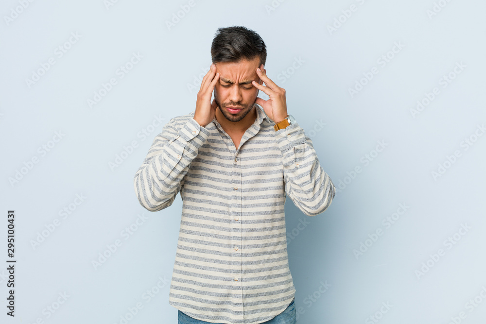 Young handsome filipino man touching temples and having headache. Young handsome filipino man touching temples and having headache.