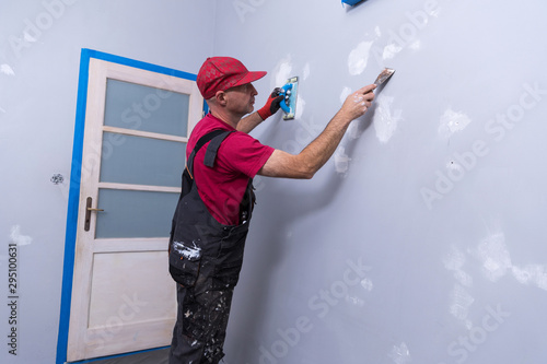 Home Painter, painter man at work, with wooden ladder and blank wall