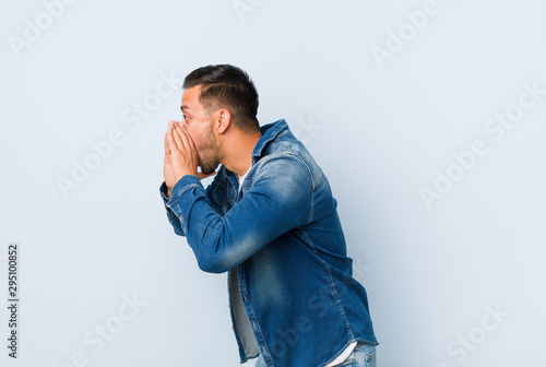 Young handsome filipino man shouts loud, keeps eyes opened and hands tense. © Asier