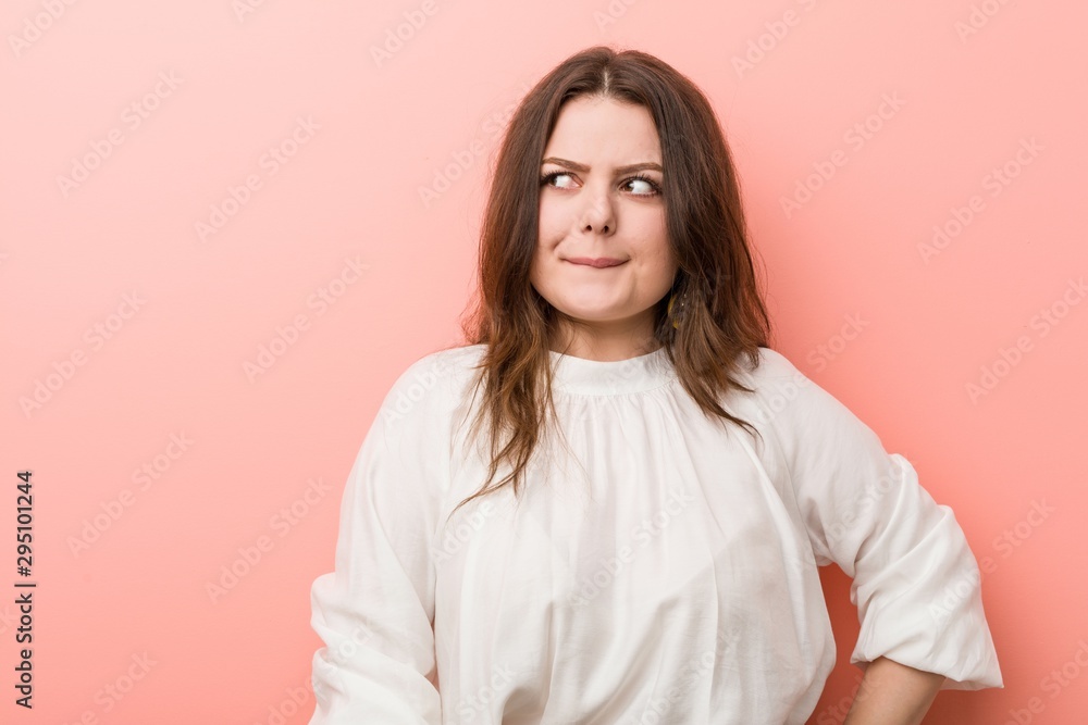 Young caucasian curvy woman standing against pink background Young caucasian curvy woman standing against pink background