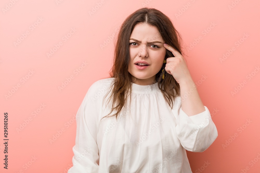 Young caucasian curvy woman standing against pink background Young caucasian curvy woman standing against pink background