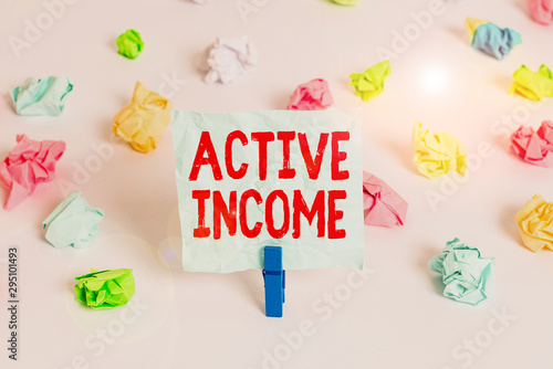 Handwriting text Active Income. Conceptual photo Royalties Salaries Pensions Financial Investments Tips Colored crumpled papers empty reminder white floor background clothespin photo