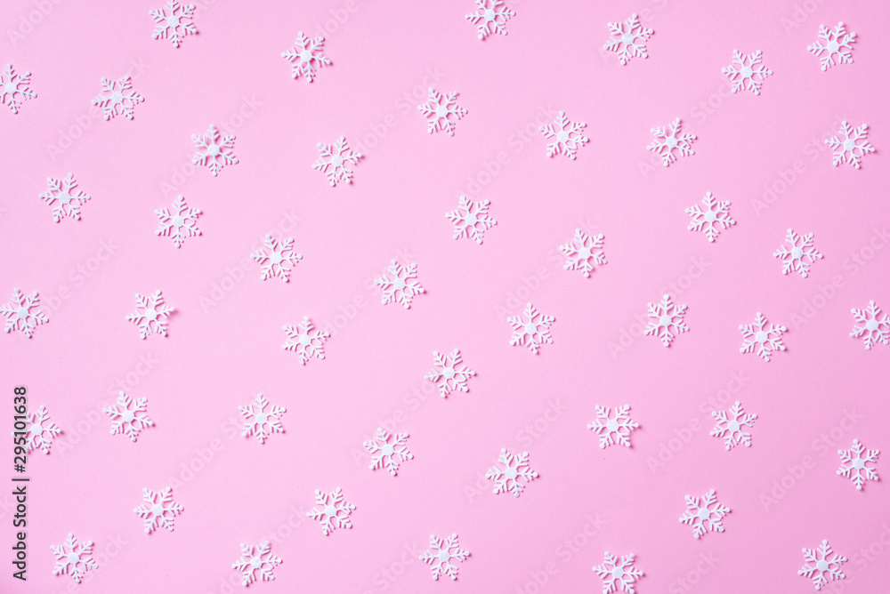Winter pattern made of white snowflakes on pink background. Top view. Flat lay. Winter composition. Christmas, new year concept. Winter pattern made of white snowflakes on pink background. Top view. Flat lay. Winter composition. Christmas, new year concept.