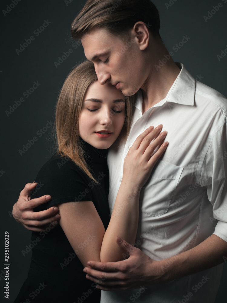 Young passionate couple in love hugging in studio.