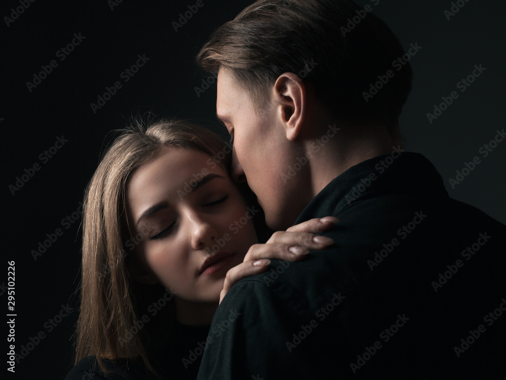 Young man and woman kissing in studio. Low key Young man and woman kissing in studio. Low key