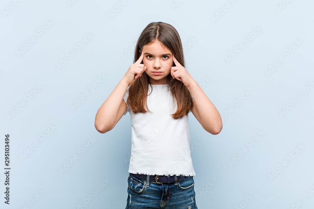 Cute girl focused on a task, keeping him forefingers pointing head. Cute girl focused on a task, keeping him forefingers pointing head.
