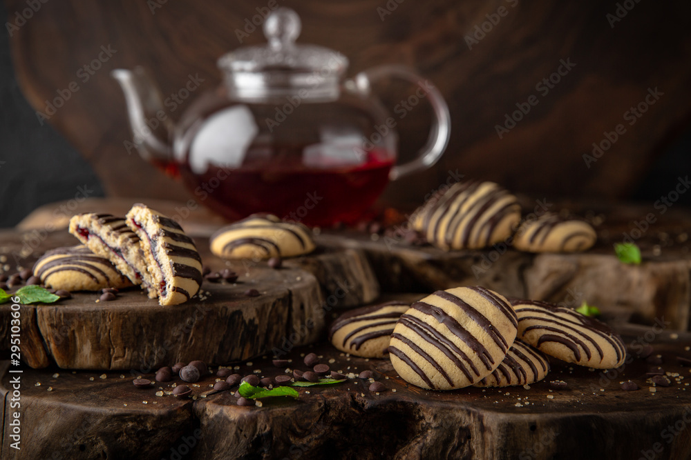 Сhocolate nut biscuit. Crispy and crumbly delicious cookies with natural ingredients: flour, nuts, seeds, pieces of chocolate, cocoa, fruit jams. Stylish still life for poster.