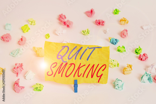 Word writing text Quit Smoking. Business photo showcasing process of discontinuing tobacco smoking or cessation Colored crumpled papers empty reminder white floor background clothespin © Artur