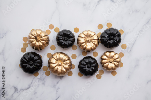 Luxury gold and black autumn pumpkin flat lay composition on a marble background