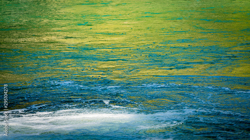 Surface of blue, green and yellow water