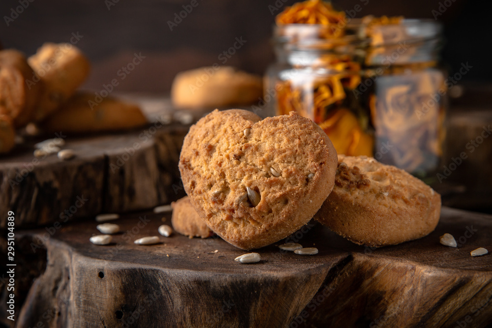 Fototapeta premium Biscuit with berry or fruit filling. Crispy and crumbly delicious cookies with natural ingredients: flour, nuts, seeds, pieces of chocolate, cocoa, fruit jams. Stylish still life for poster.