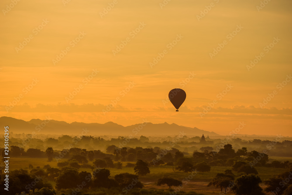 Sunrise over Bagan with Balloon at a foggy sky, Myanmar temples in the Archaeological Park Sunrise over Bagan with Balloon at a foggy sky, Myanmar temples in the Archaeological Park