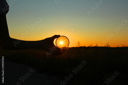 Quadro su tela Polarizing filter in hand on sunset background.