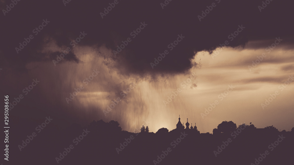 Dramatic sky with rainy clouds in sepia tones