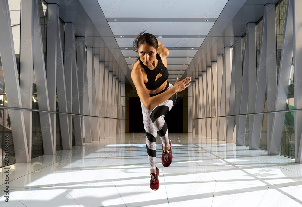 Sporty young woman running on sidewalk Sporty young woman running on sidewalk