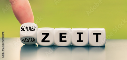 Wechsel von Sommerzeit auf Winterzeit oder umgekehrt.Hand dreht einen Würfel und ändert das Wort 