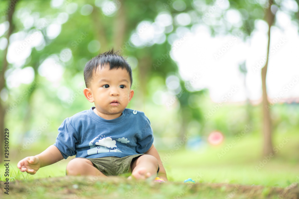 Adorable infant toddler baby boy playing in green park Adorable infant toddler baby boy playing in green park