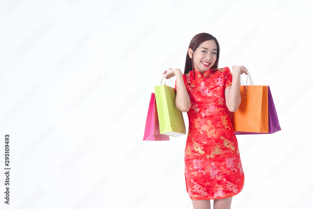 Chinese woman wearing Cheongsam red dress hold shopping bag.Happy woman shopping concept.